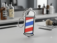 Llavero NFC con forma de poste de barbero impreso en 3D, con franjas roja, azul y blanca, sobre el mostrador de una barbería