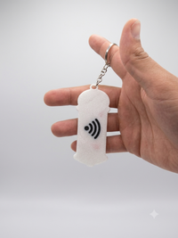 Parte trasera del llavero con el símbolo NFC grabado, sostenido en la mano