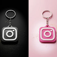 Llavero NFC de Instagram en negro y en rosa vistos de cerca sobre fondo oscuro y rosa