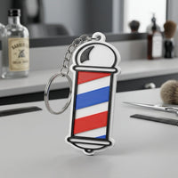 Llavero NFC con forma de poste de barbero impreso en 3D, con franjas roja, azul y blanca, sobre el mostrador de una barbería